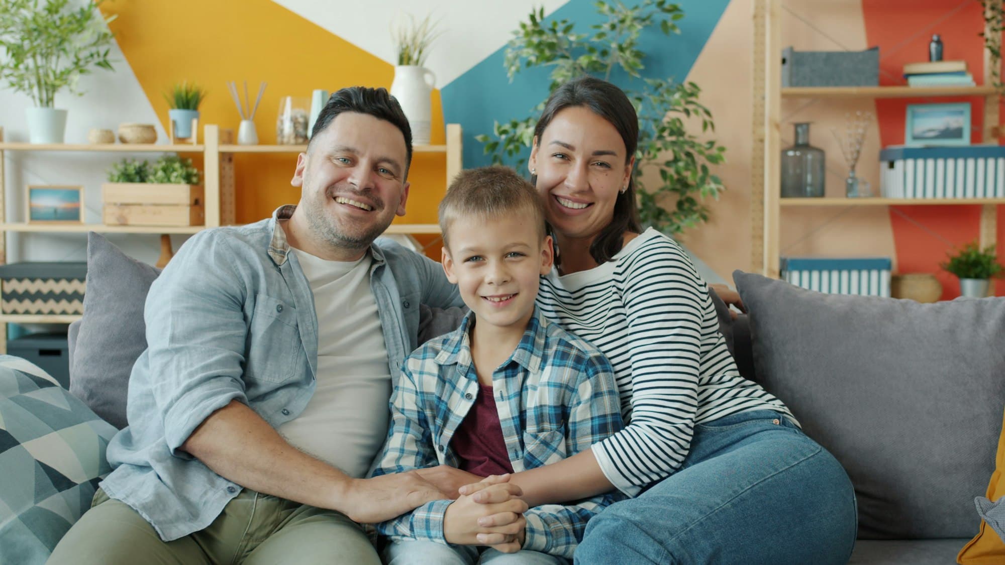 Famiglia sorridente seduta sul divano di casa
